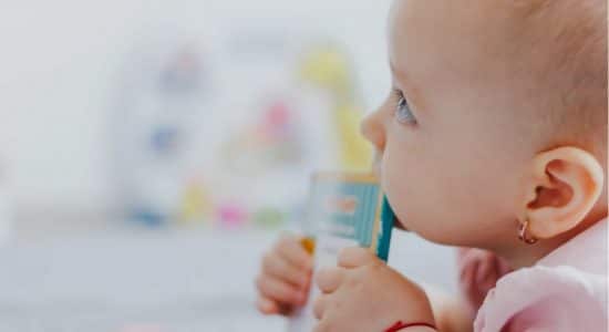 Bébé en pleine poussée dentaire qui mâchouille un objet